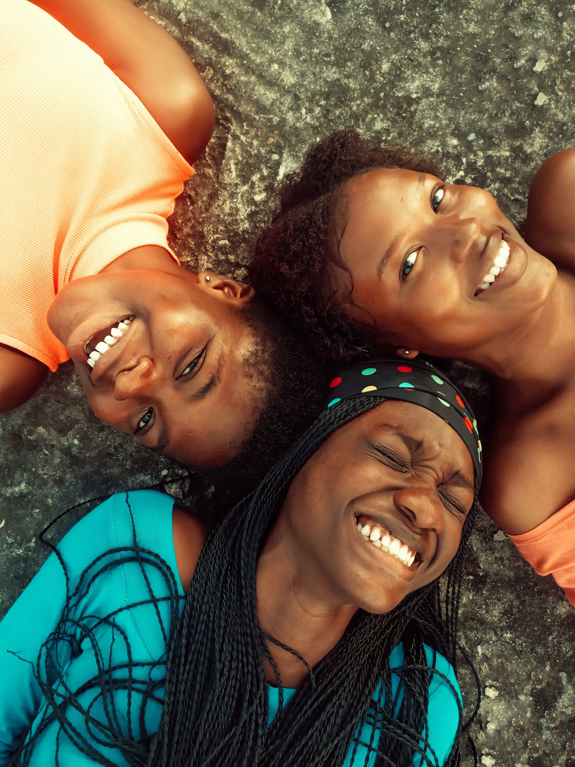 Three girls lying together and laughing